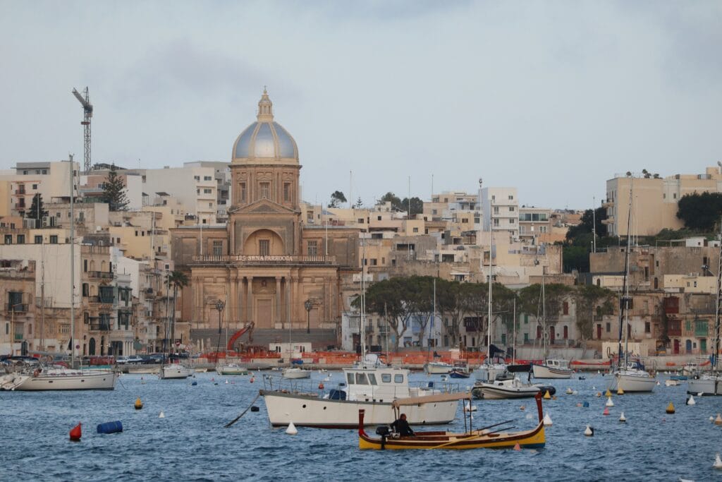 Traditional dgħajsa harbour boat crossing the Grand Harbour from Bormla to Valletta